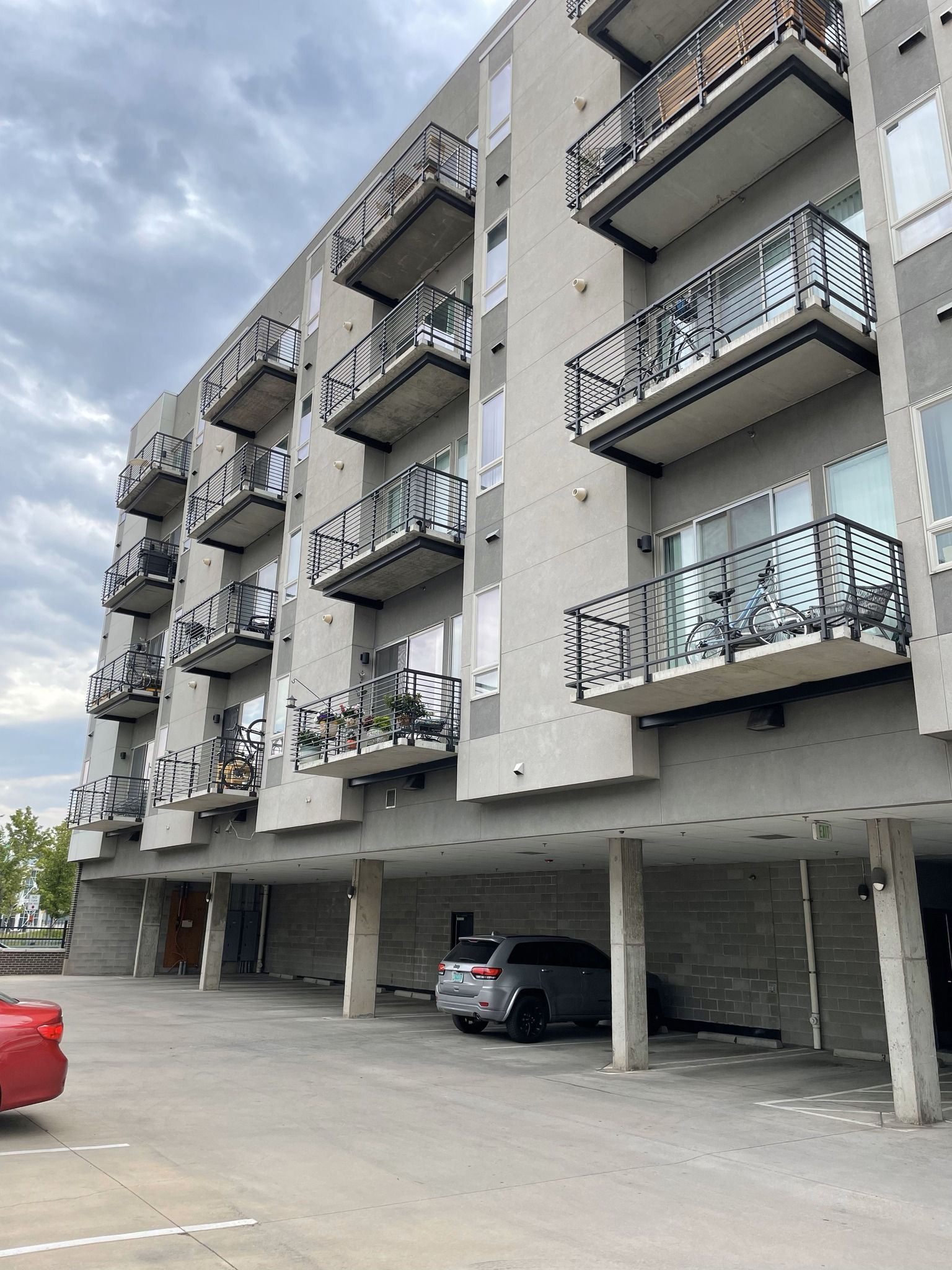 A building with a lot of balconies and cars parked in front of it
