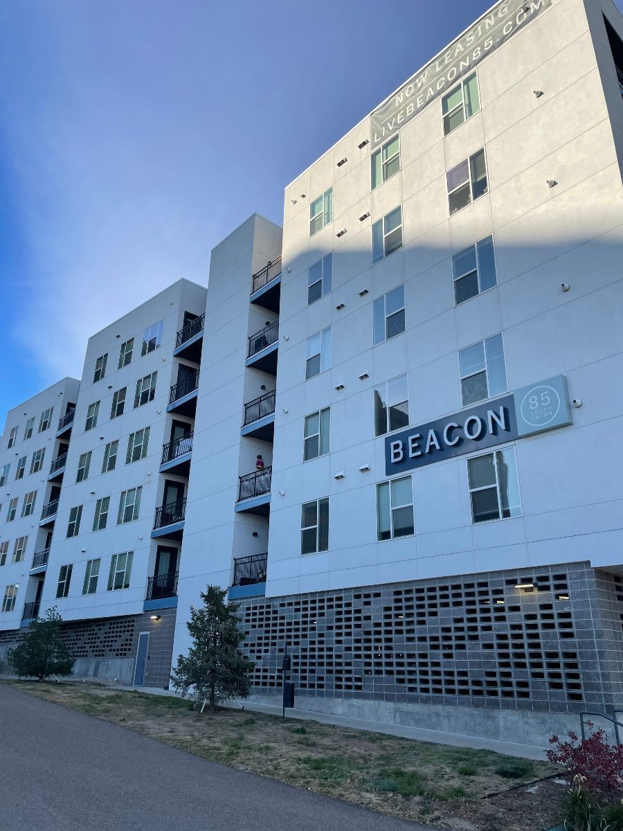 A large white building with a sign that says beacon on it