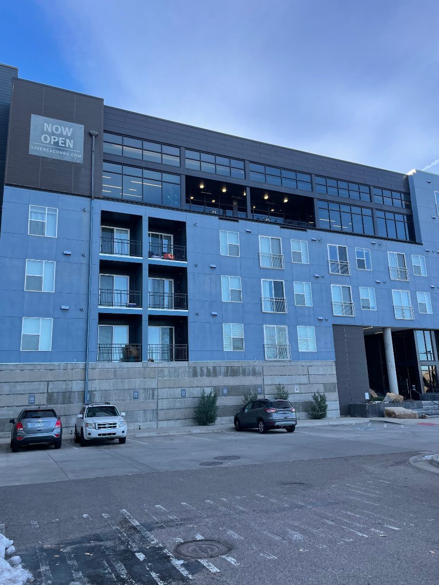 A large blue building with cars parked in front of it