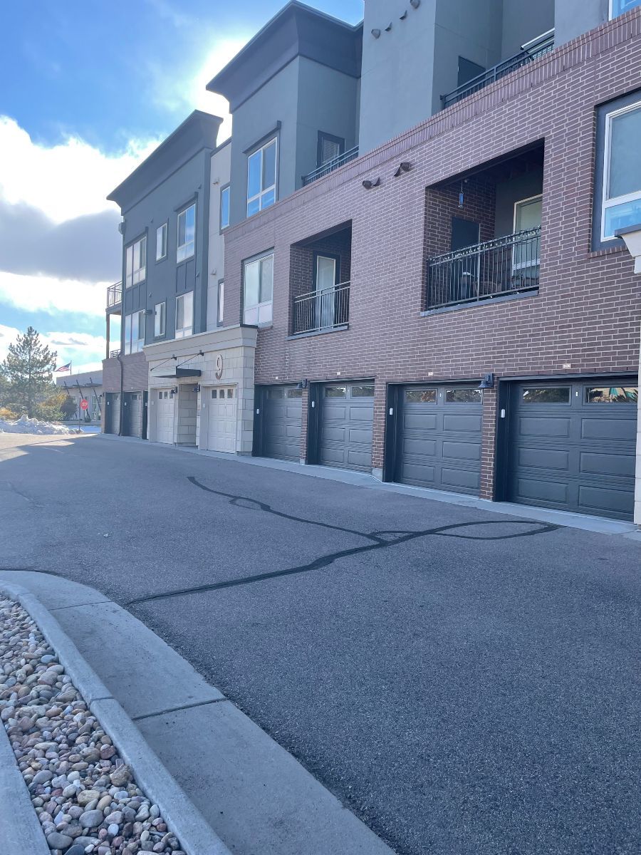 A row of apartment buildings with garages and balconies.