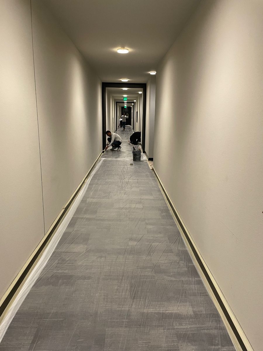A long hallway with a carpeted floor in a building.