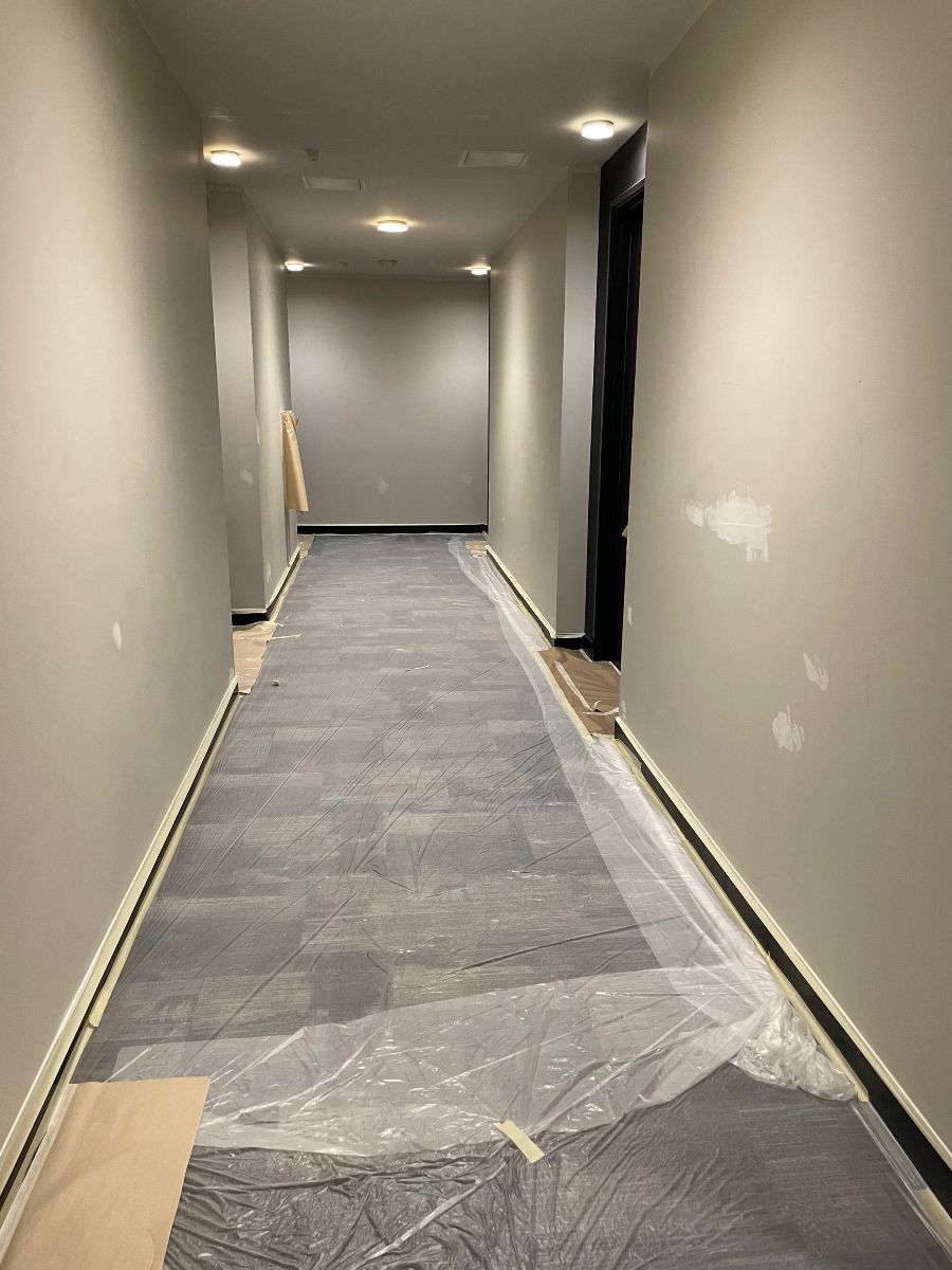 A long hallway with plastic covering the floor and walls.