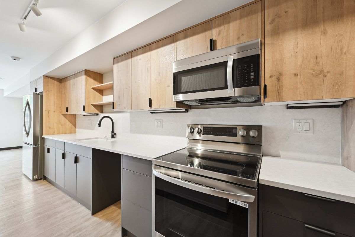 A kitchen with stainless steel appliances and wooden cabinets.