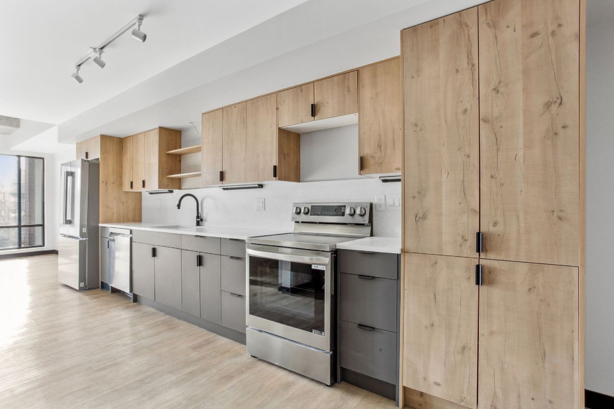 A kitchen with stainless steel appliances and wooden cabinets.