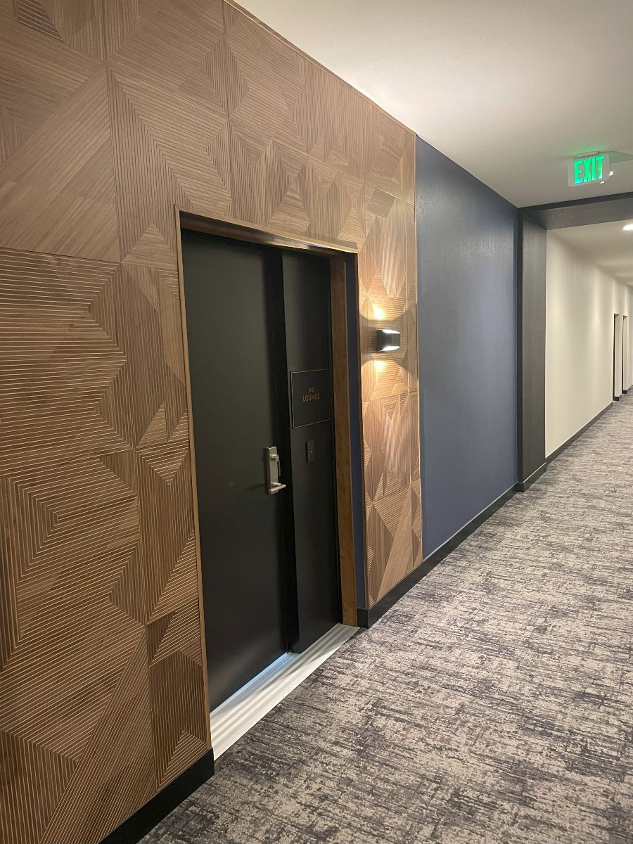 A long hallway with a door in the middle of it.
