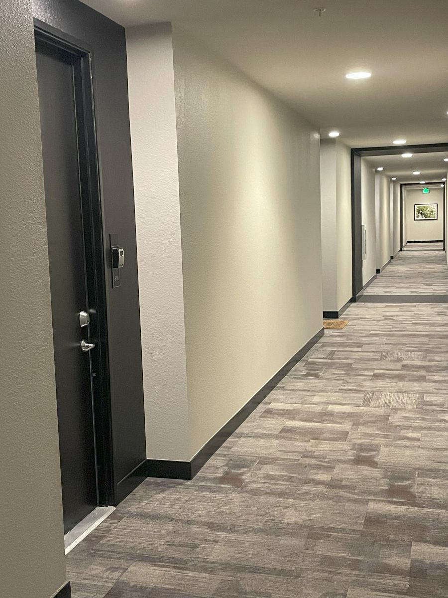 A long hallway with a door in the middle of it