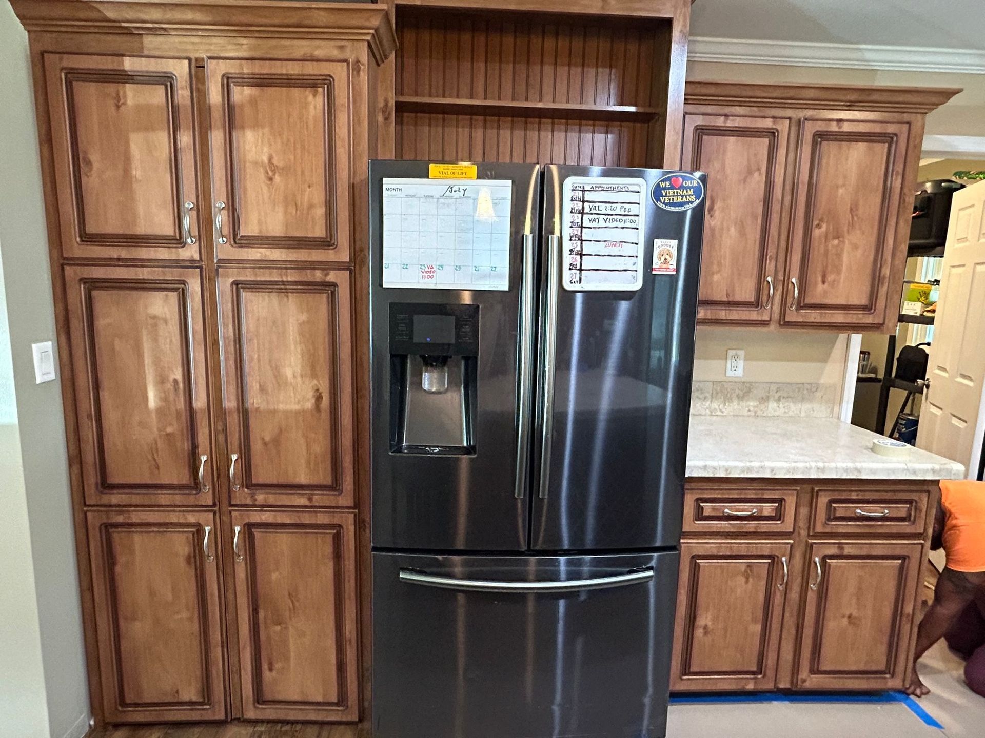 Kitchen with wooden cabinets, refrigerator, and countertop.