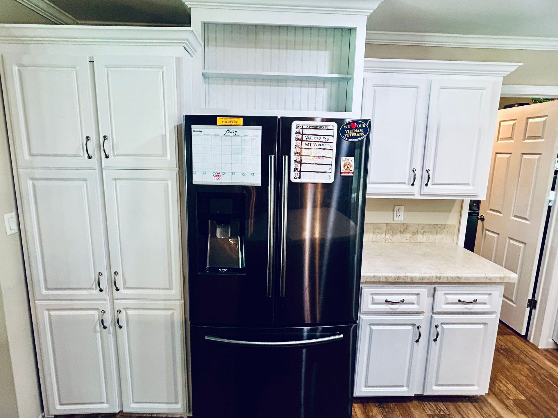 Kitchen with white cabinets, refrigerator, and countertop.