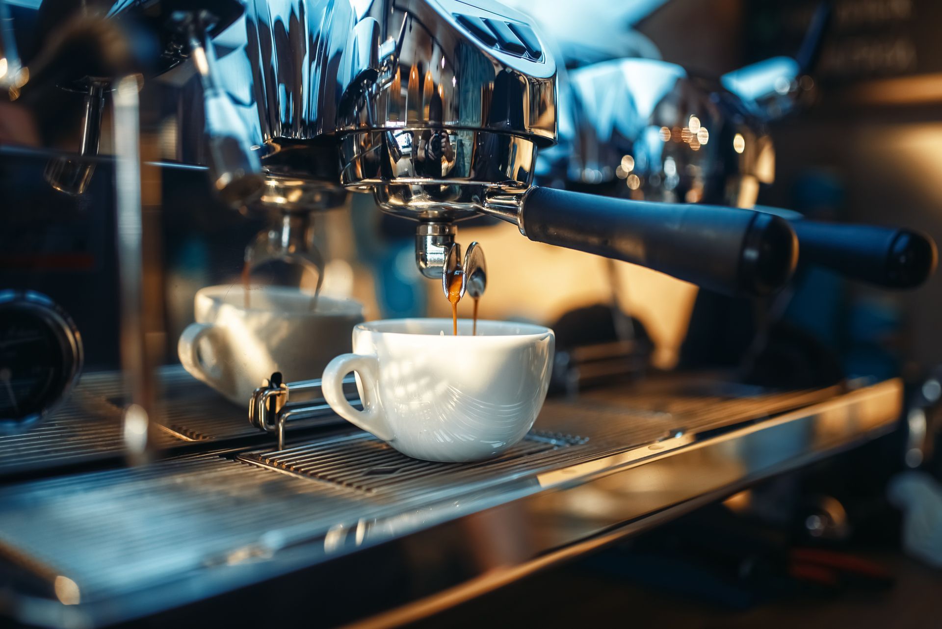 Close view of espresso machine pouring steaming coffee.