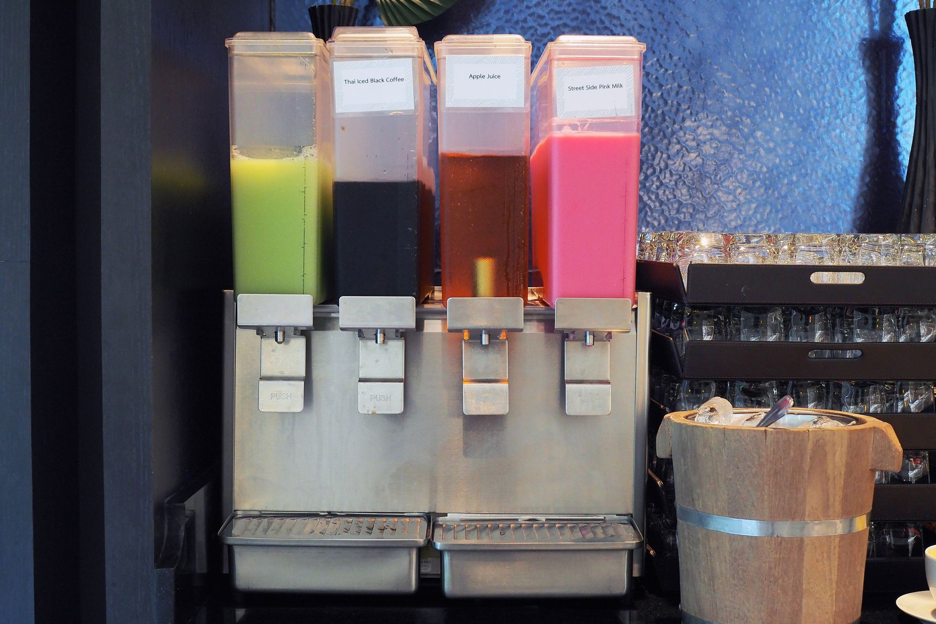 Displaying a cold beverage machine on the counter, showcasing fresh juice varieties.