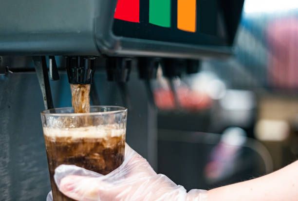 Man pours a ice soft drink cola.