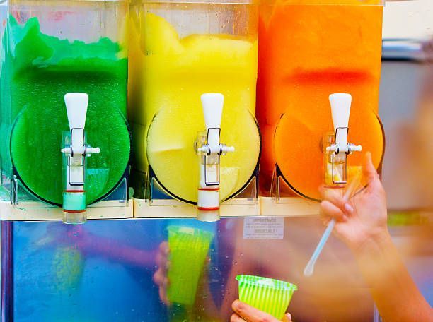 Colorful frozen beverage machines with green, yellow, and orange slush drinks