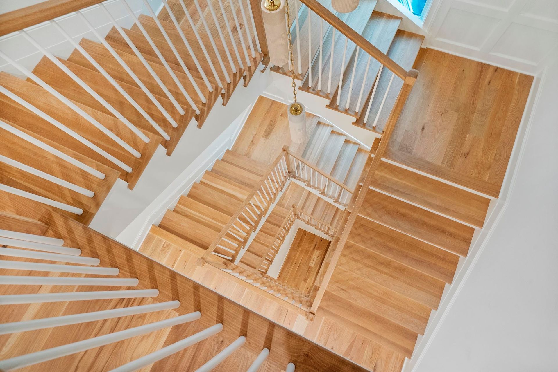 Looking down at a wooden spiral staircase in a house.