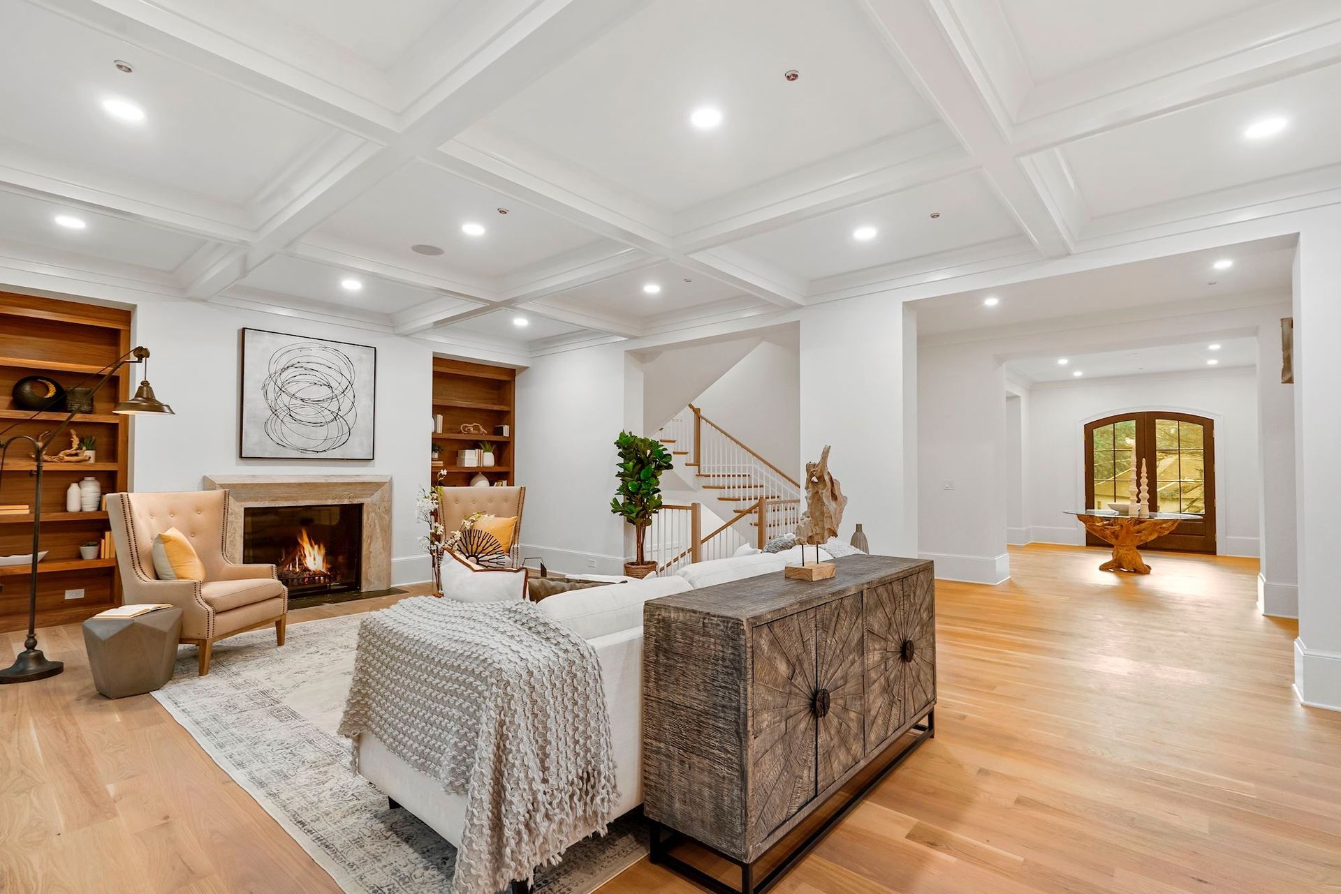 A living room with a fireplace , couch , chairs and a dresser.