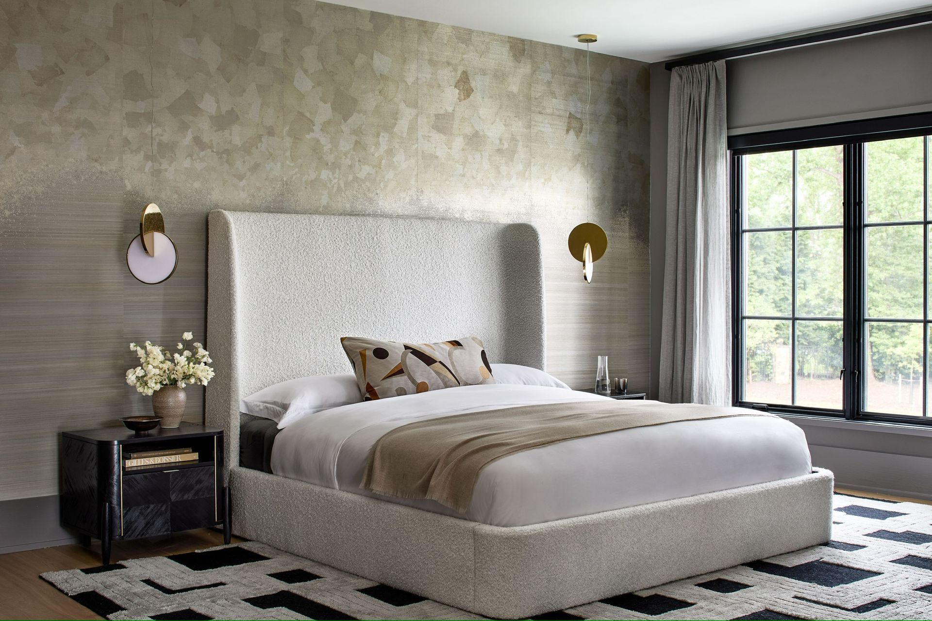 A bedroom with a bed , nightstand , rug and window.