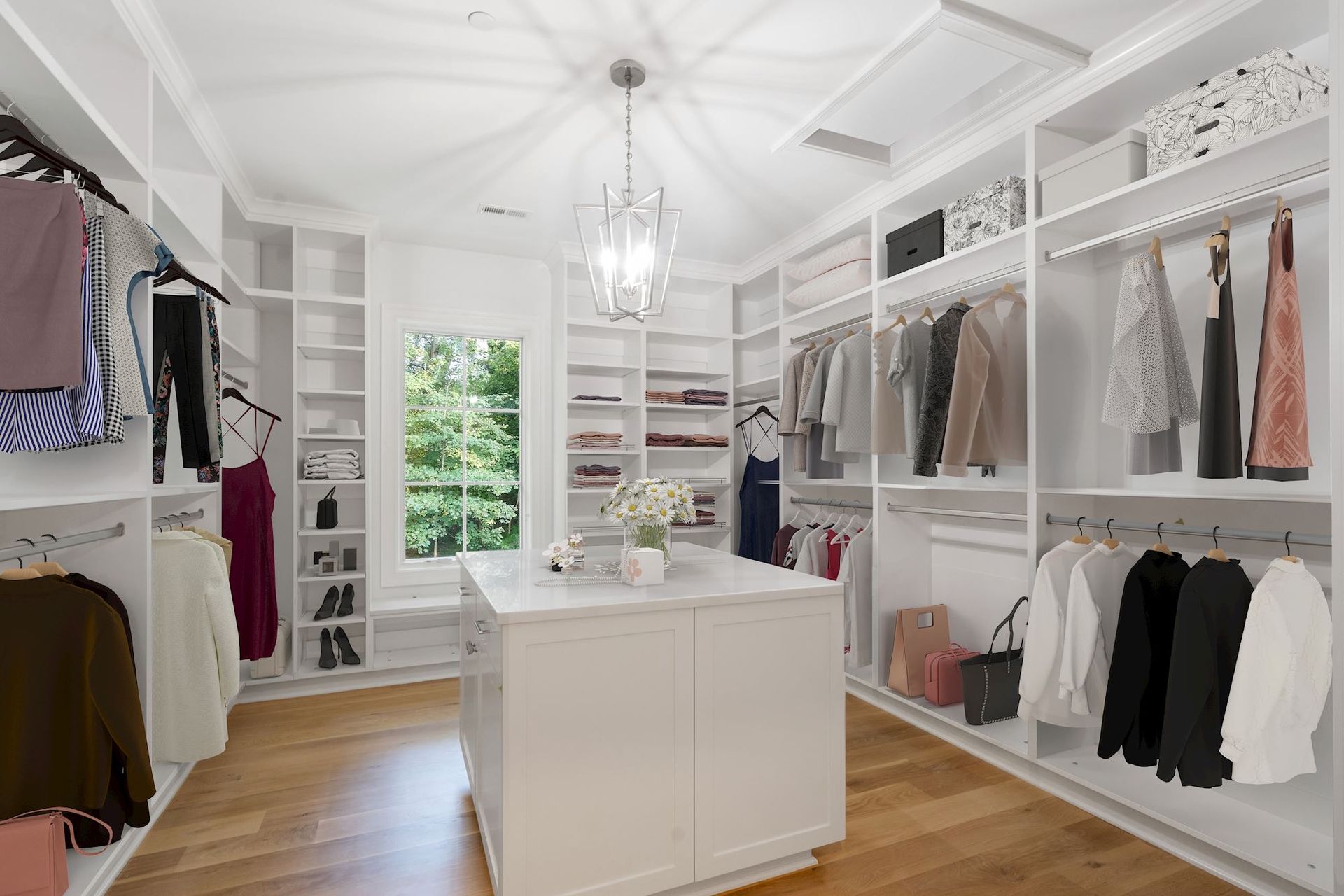 A walk in closet filled with lots of clothes and a large island.