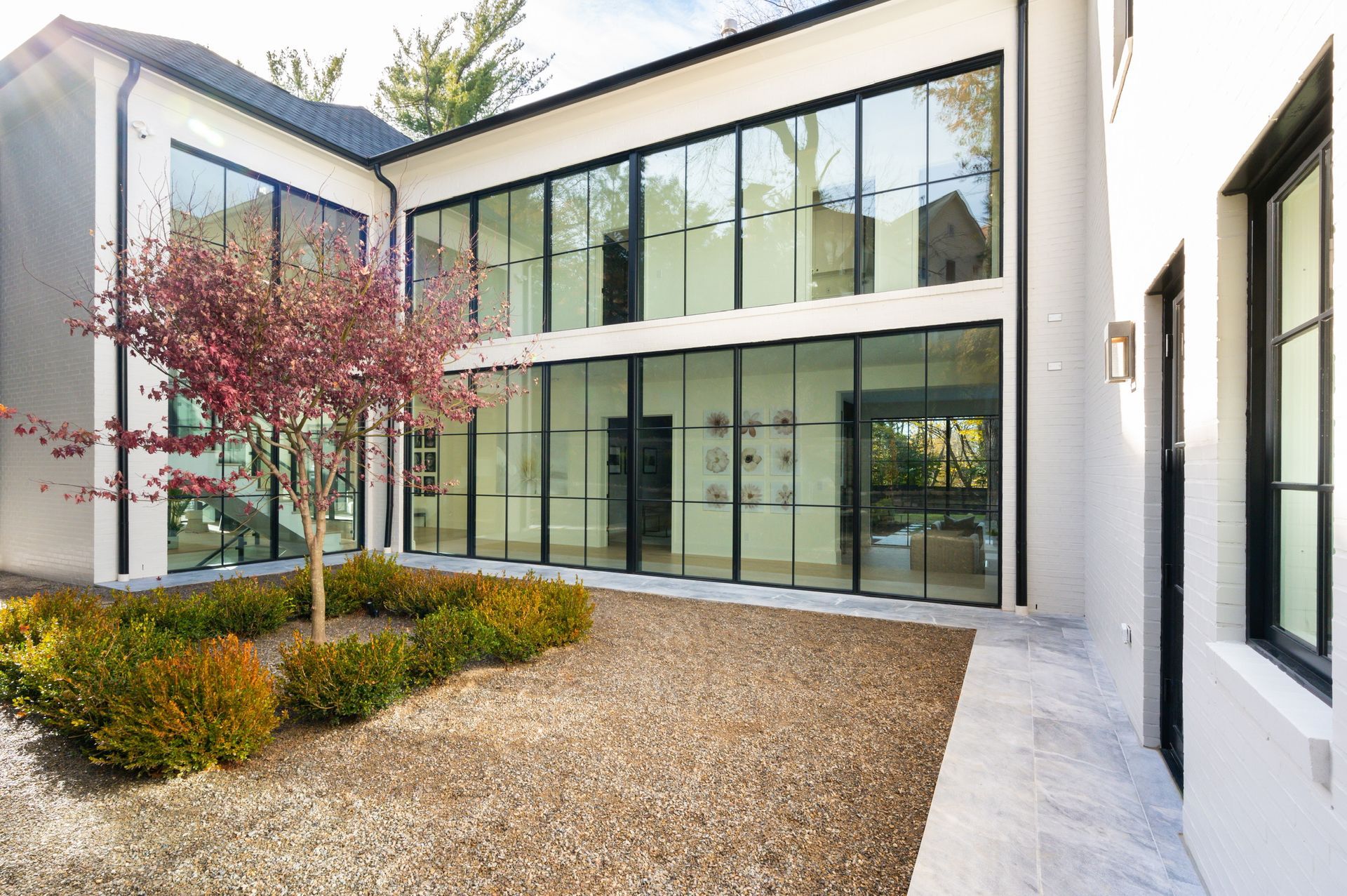A large white house with a lot of windows and a tree in front of it.