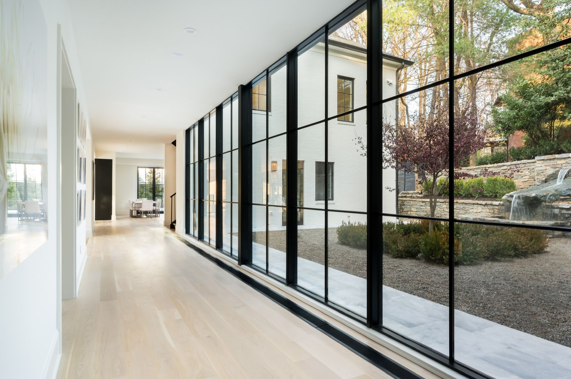 A long hallway with lots of windows leading to a house.