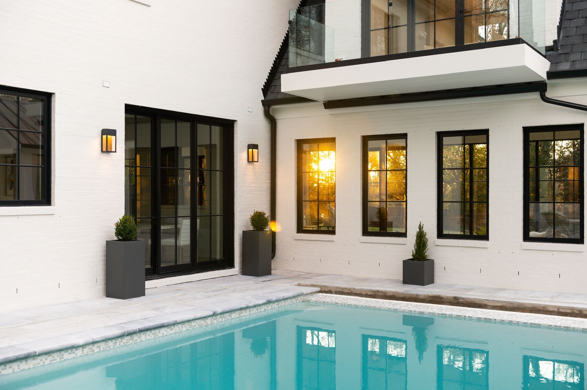 A large white house with a swimming pool in front of it.