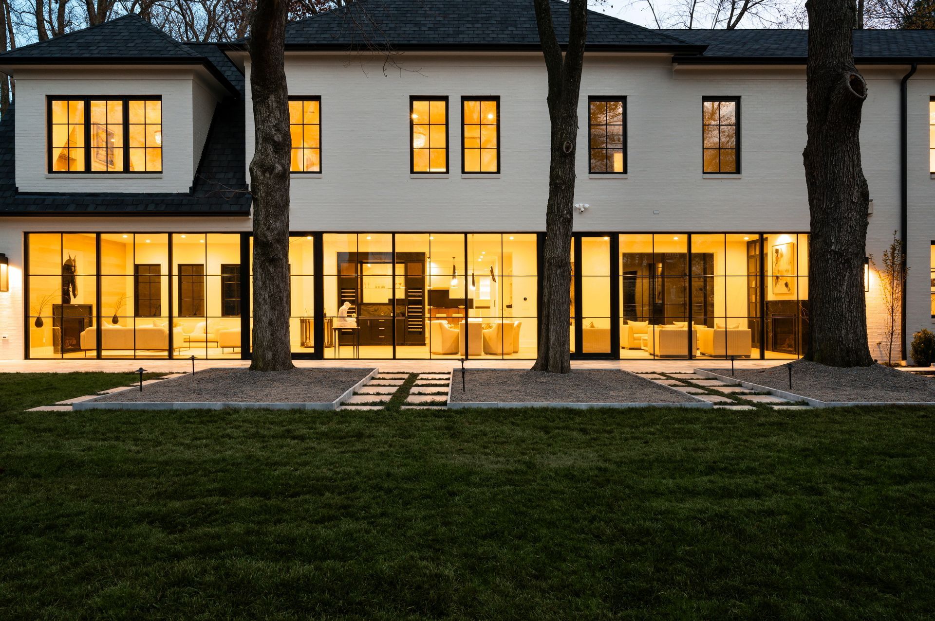 A large white house with lots of windows is lit up at night