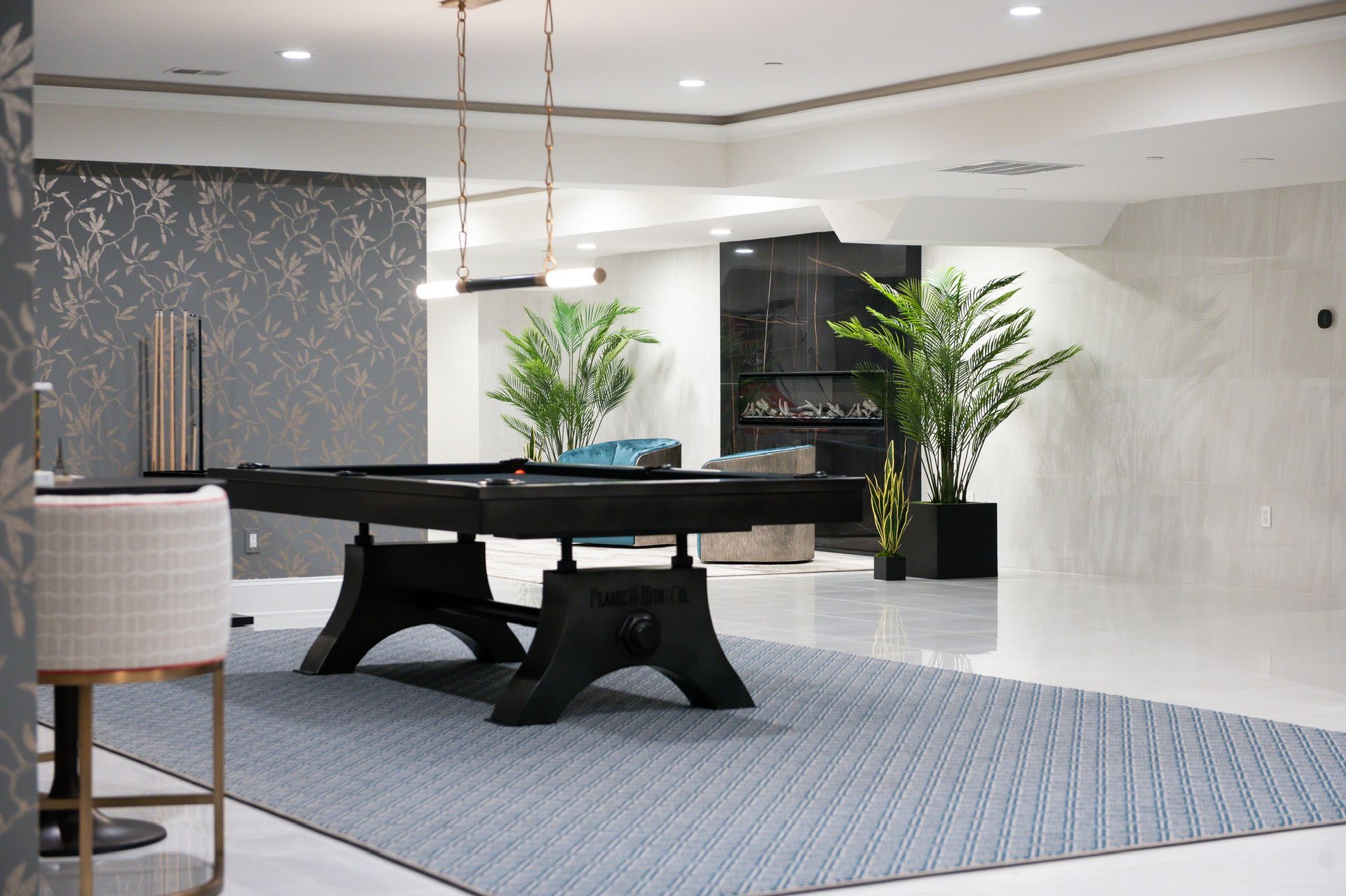 A pool table is in the middle of a living room.