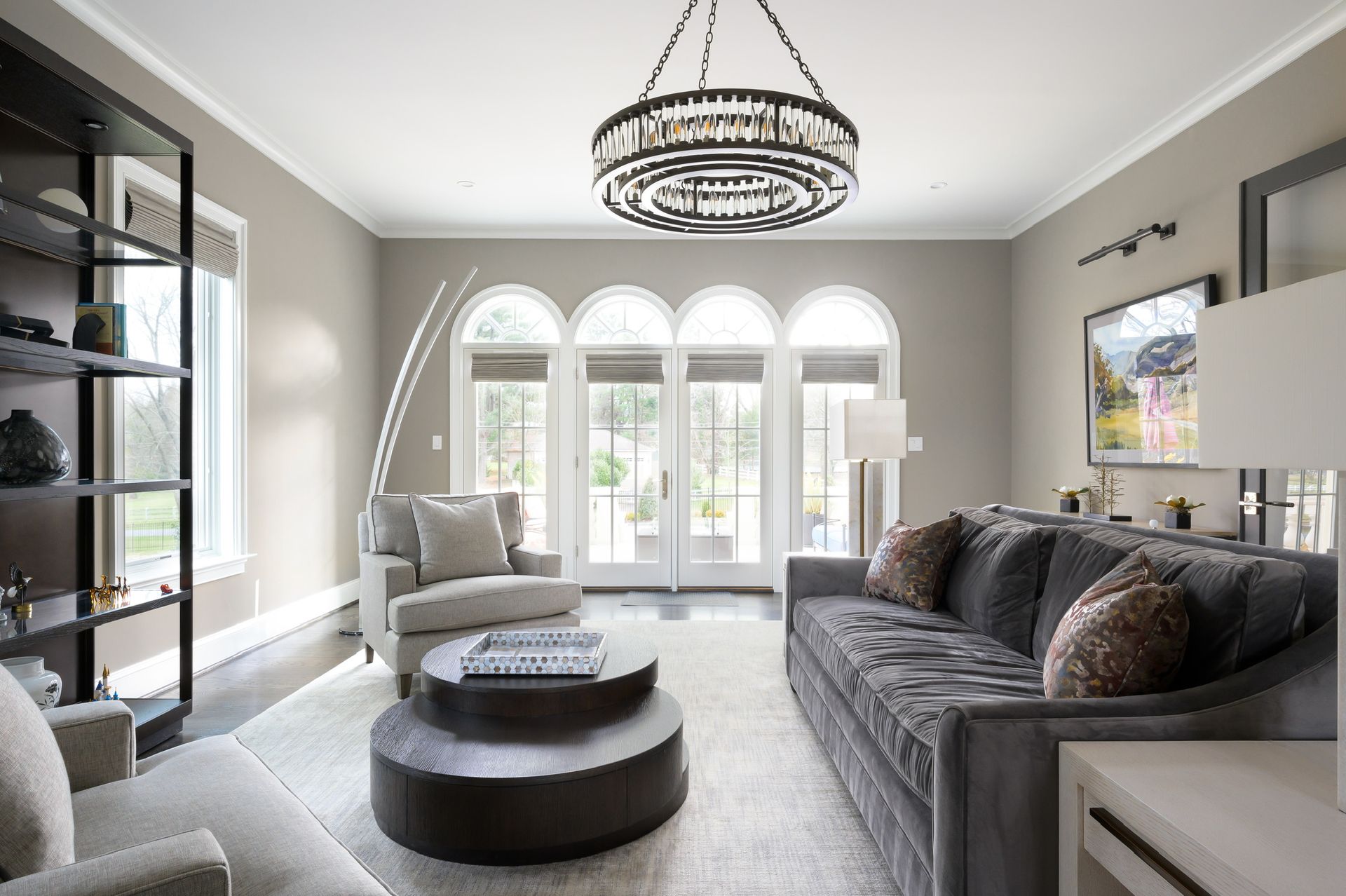 A living room with a couch , chairs , and a round coffee table.
