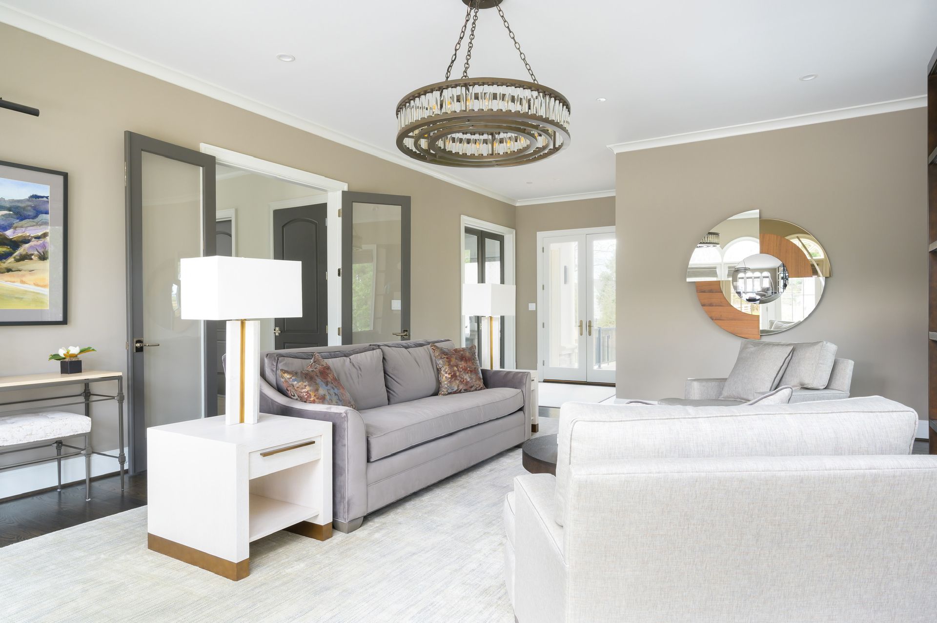 A living room with a couch , chairs , lamps and a chandelier.
