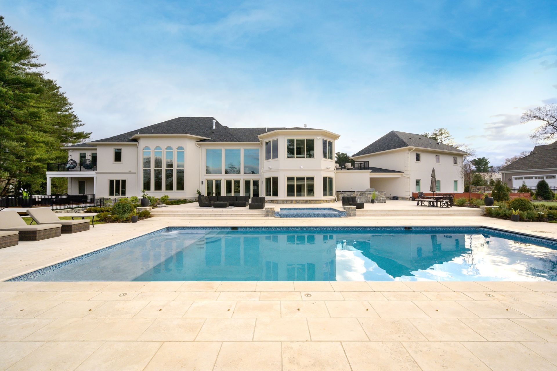 A large white house with a large swimming pool in front of it