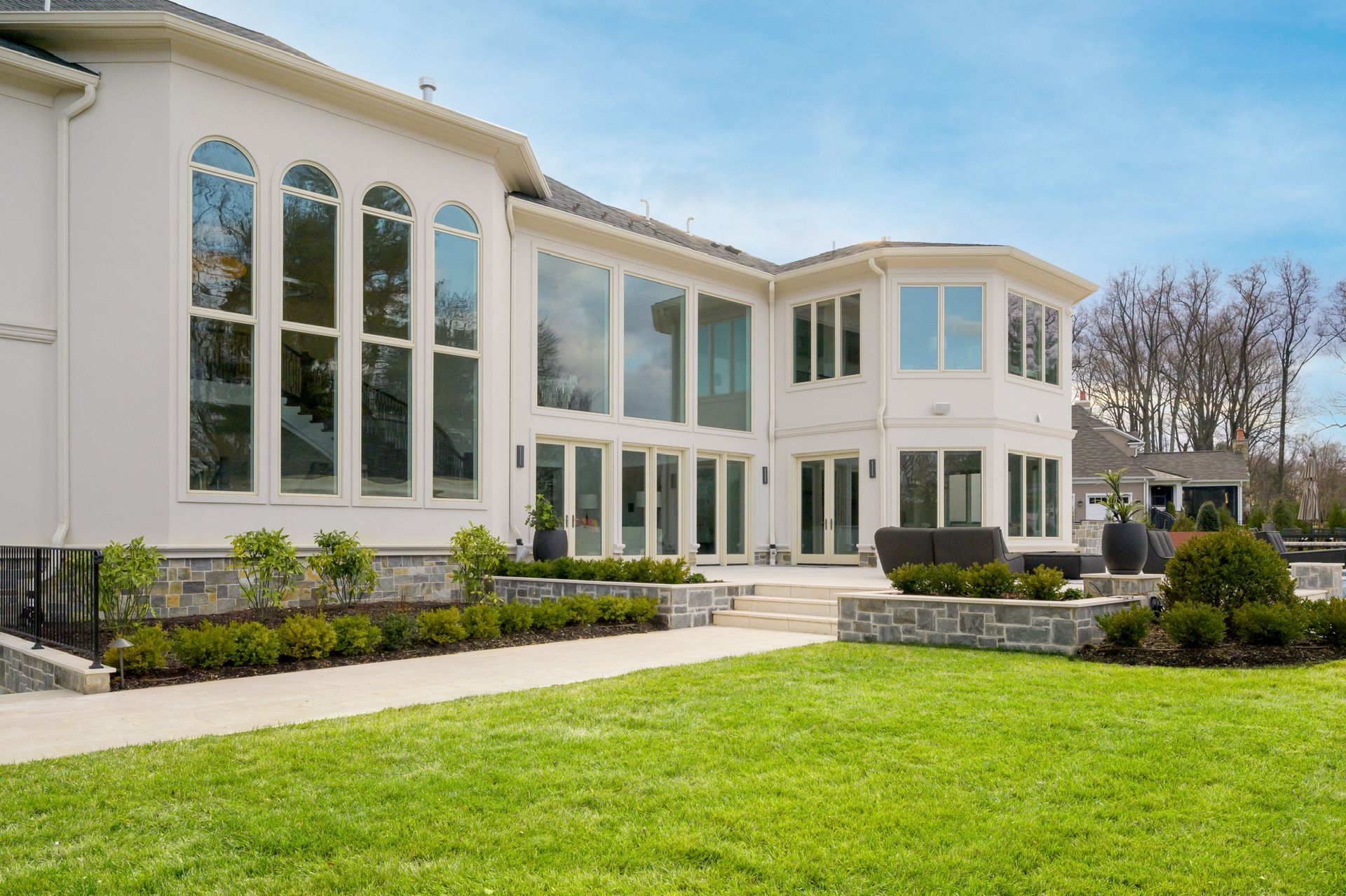 A large white house with a lot of windows and a large lawn in front of it.