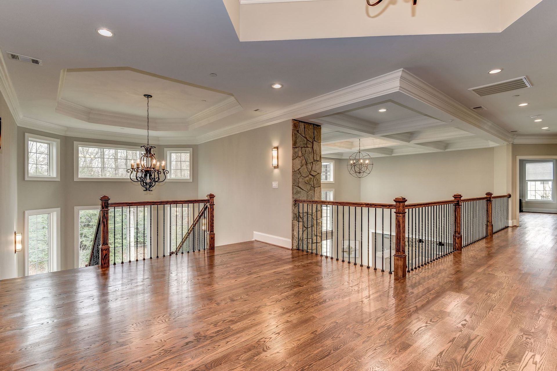 A large empty room with hardwood floors and a staircase