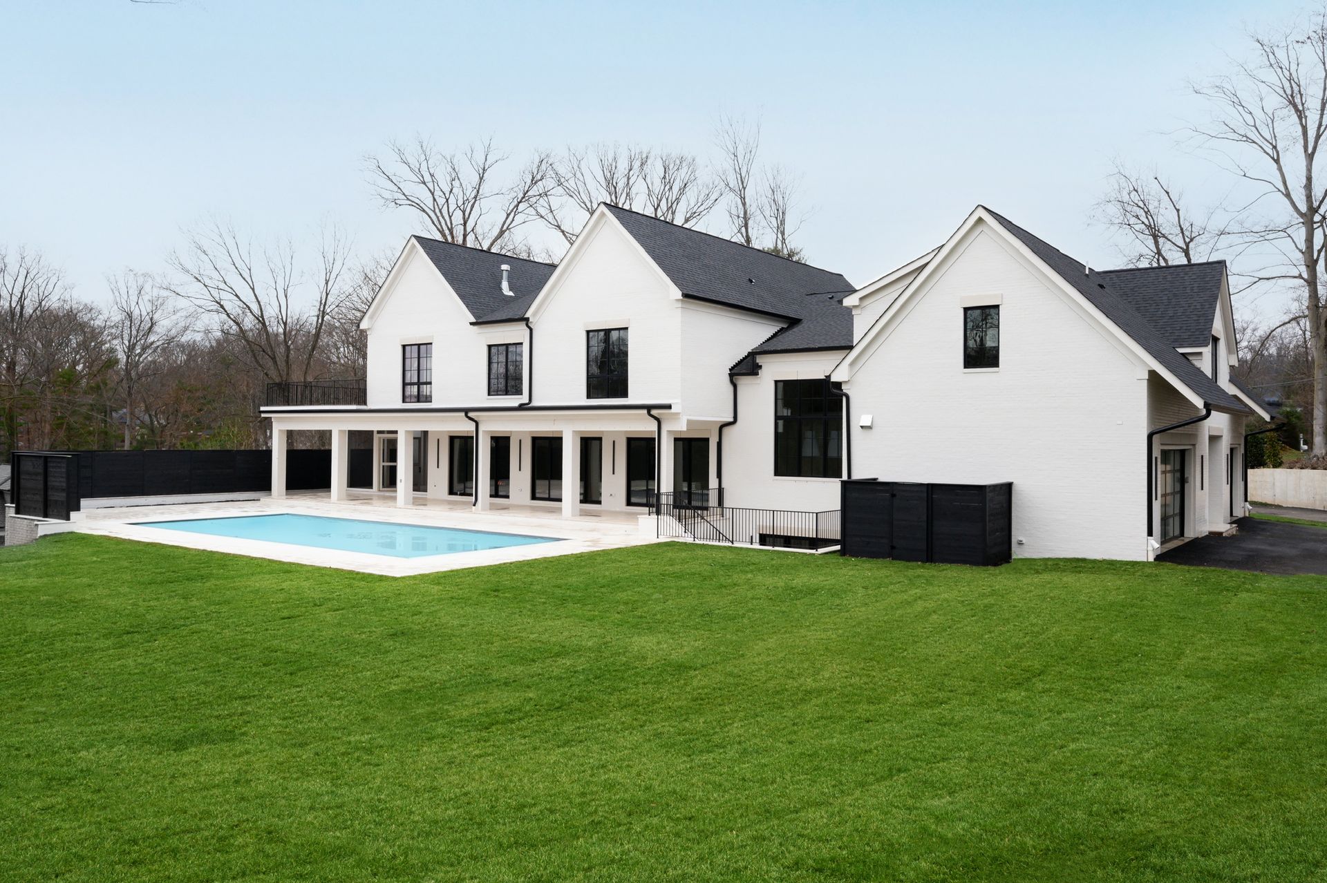 A large white house with a swimming pool in the backyard.