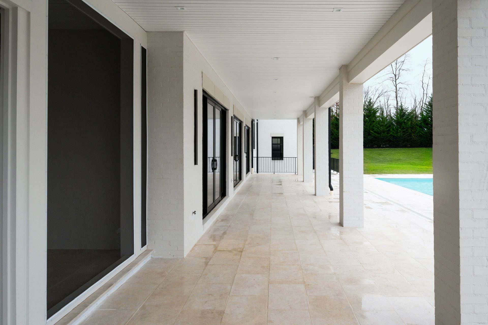 A long hallway leading to a swimming pool in a house
