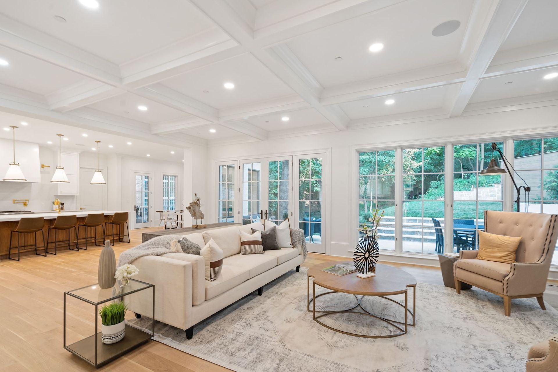 A living room with a couch , chair , coffee table and lots of windows.