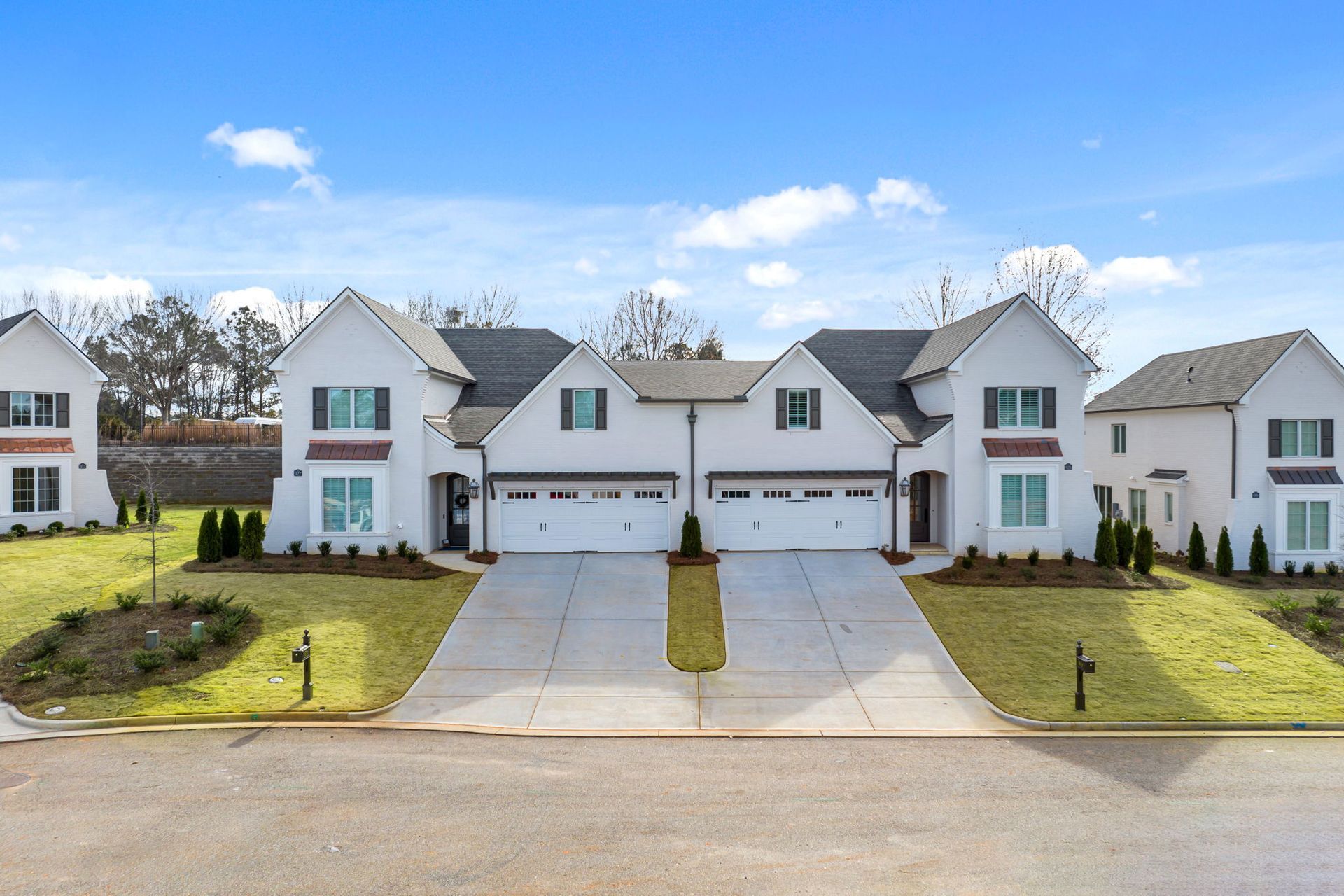 A row of white houses with a blue sky in the background
