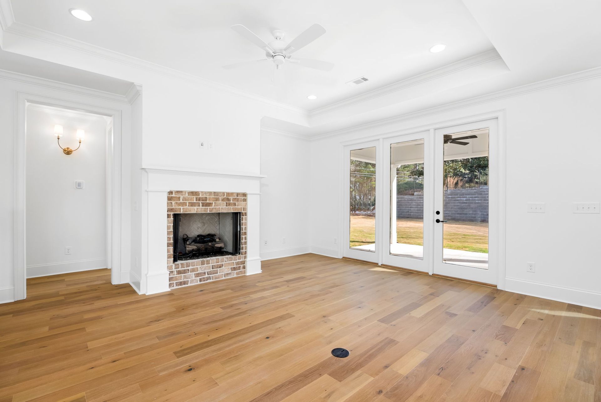 An empty living room with hardwood floors and a fireplace.
