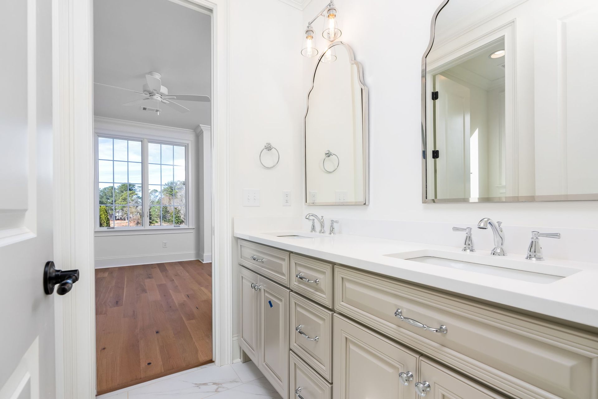A bathroom with two sinks , a mirror and a window.