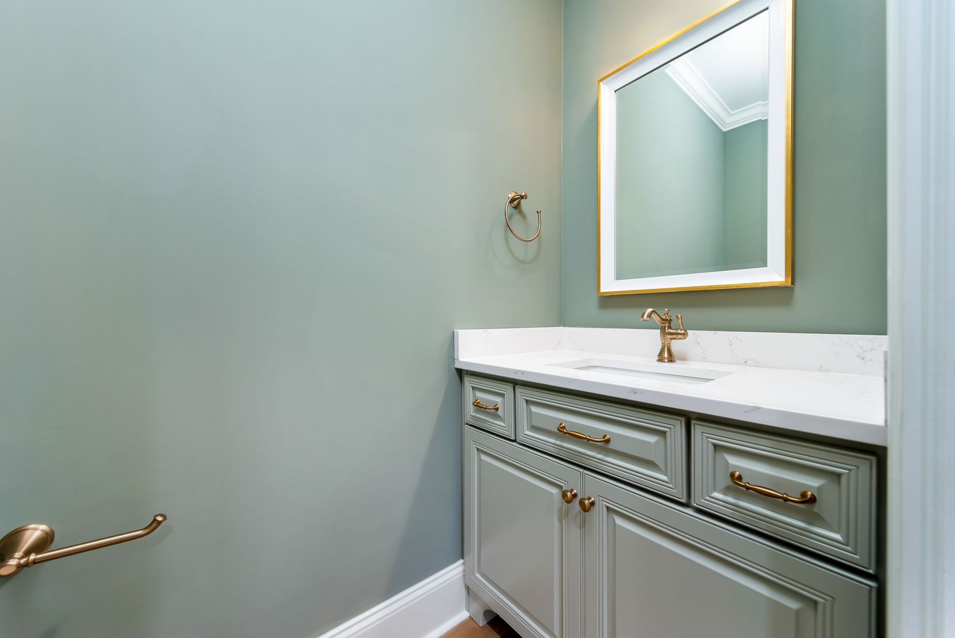 A bathroom with a sink , mirror and cabinets.