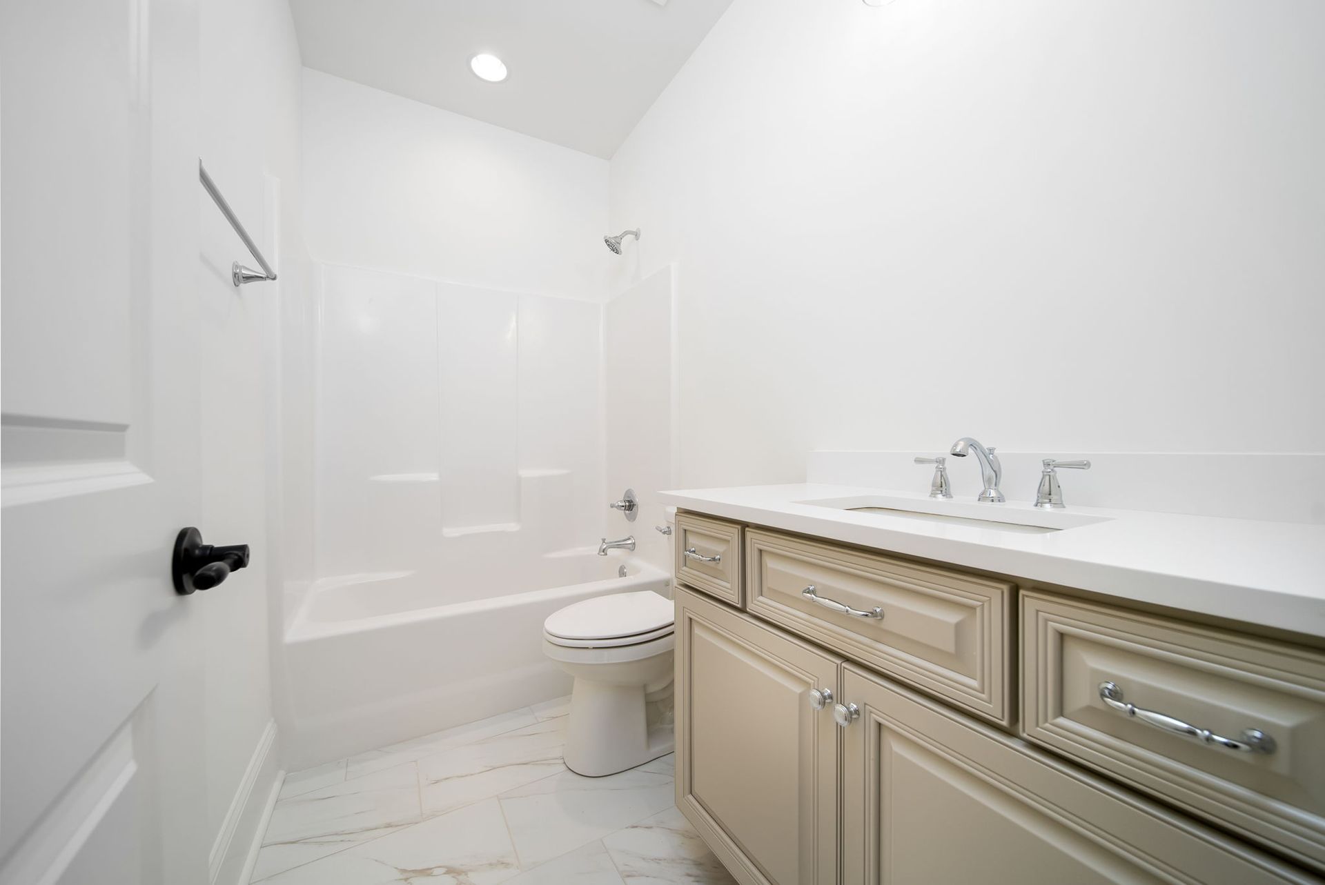 A bathroom with a toilet , sink , and bathtub.