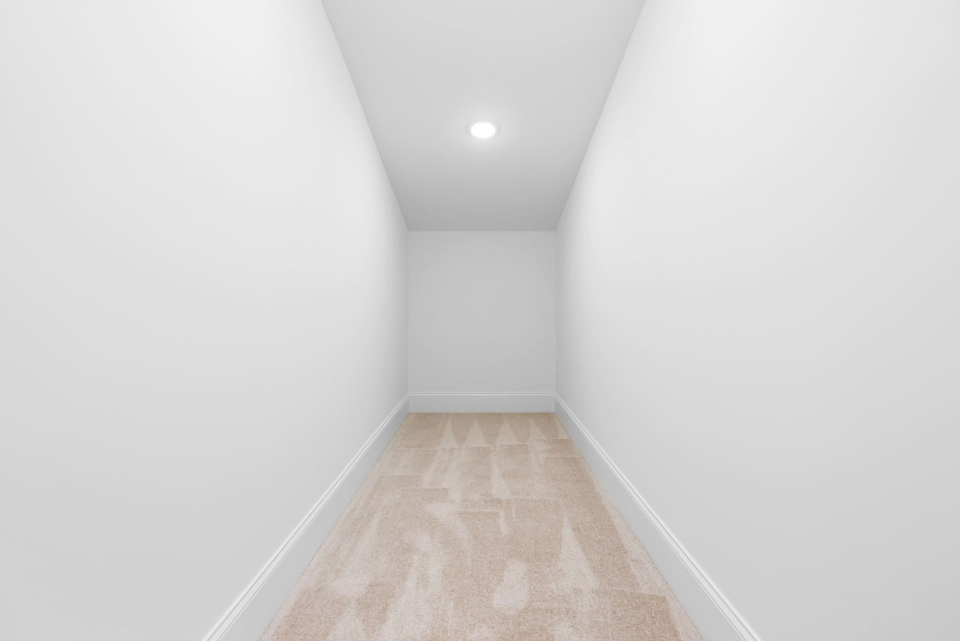 An empty hallway with white walls and a wooden floor.