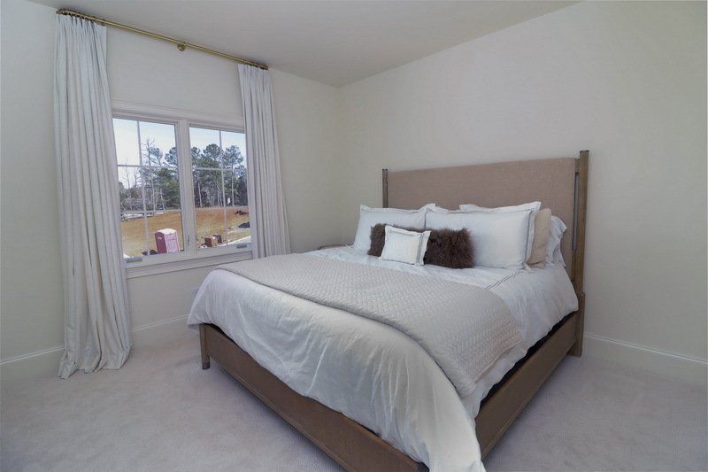 A bedroom with a large bed and a window