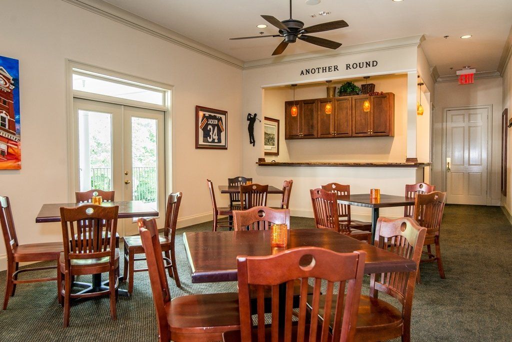 A restaurant with tables and chairs and a ceiling fan