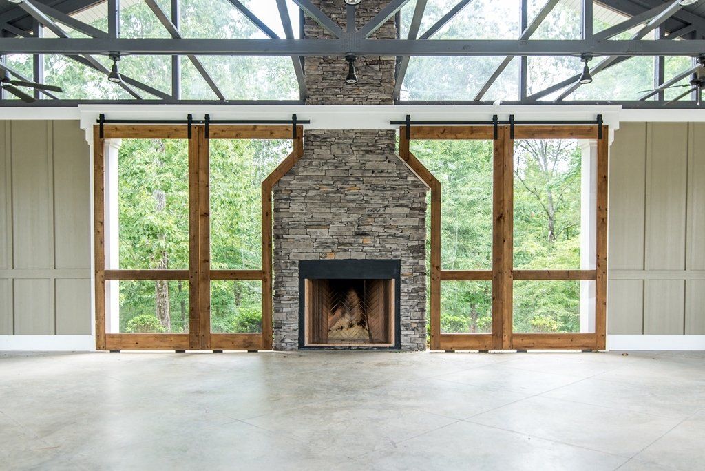 There is a fireplace in the middle of the room with a lot of windows.