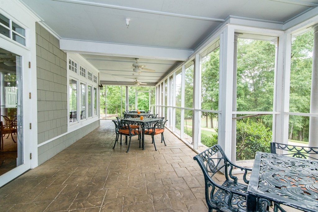 A screened in porch with a table and chairs