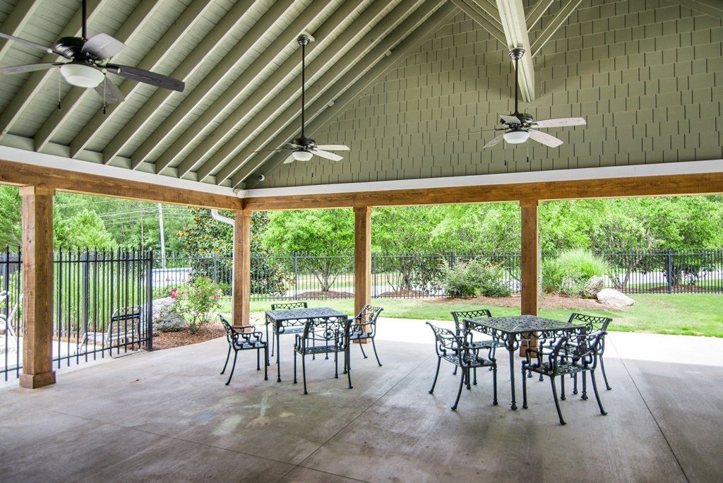 A pavilion with tables and chairs under a ceiling fan.