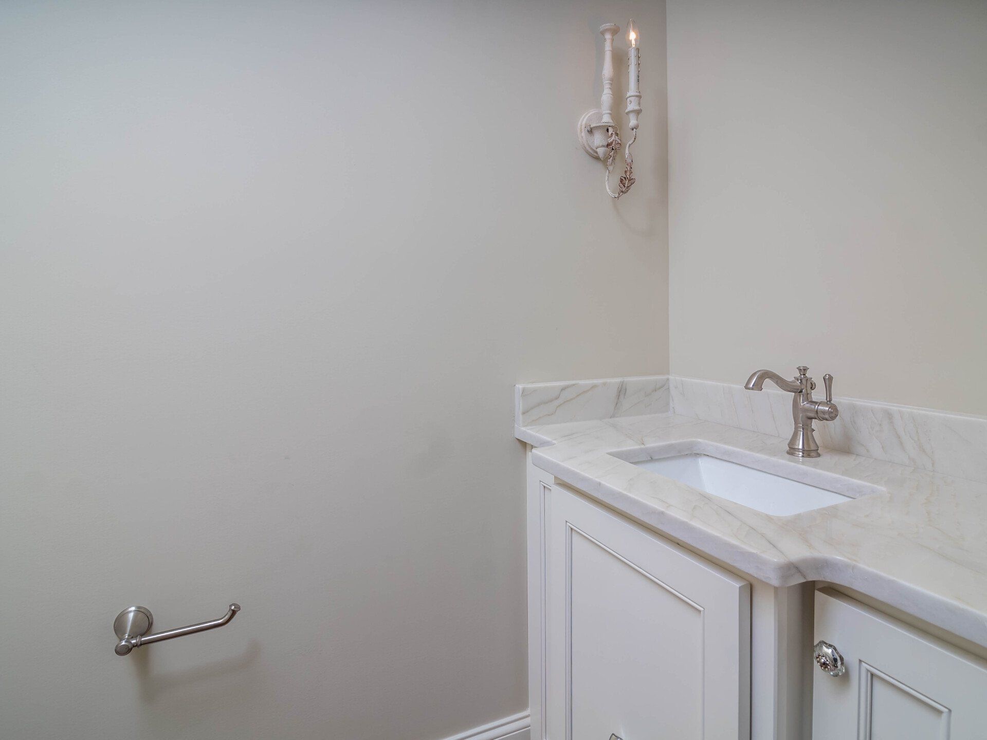 A bathroom with a sink and a toilet paper holder