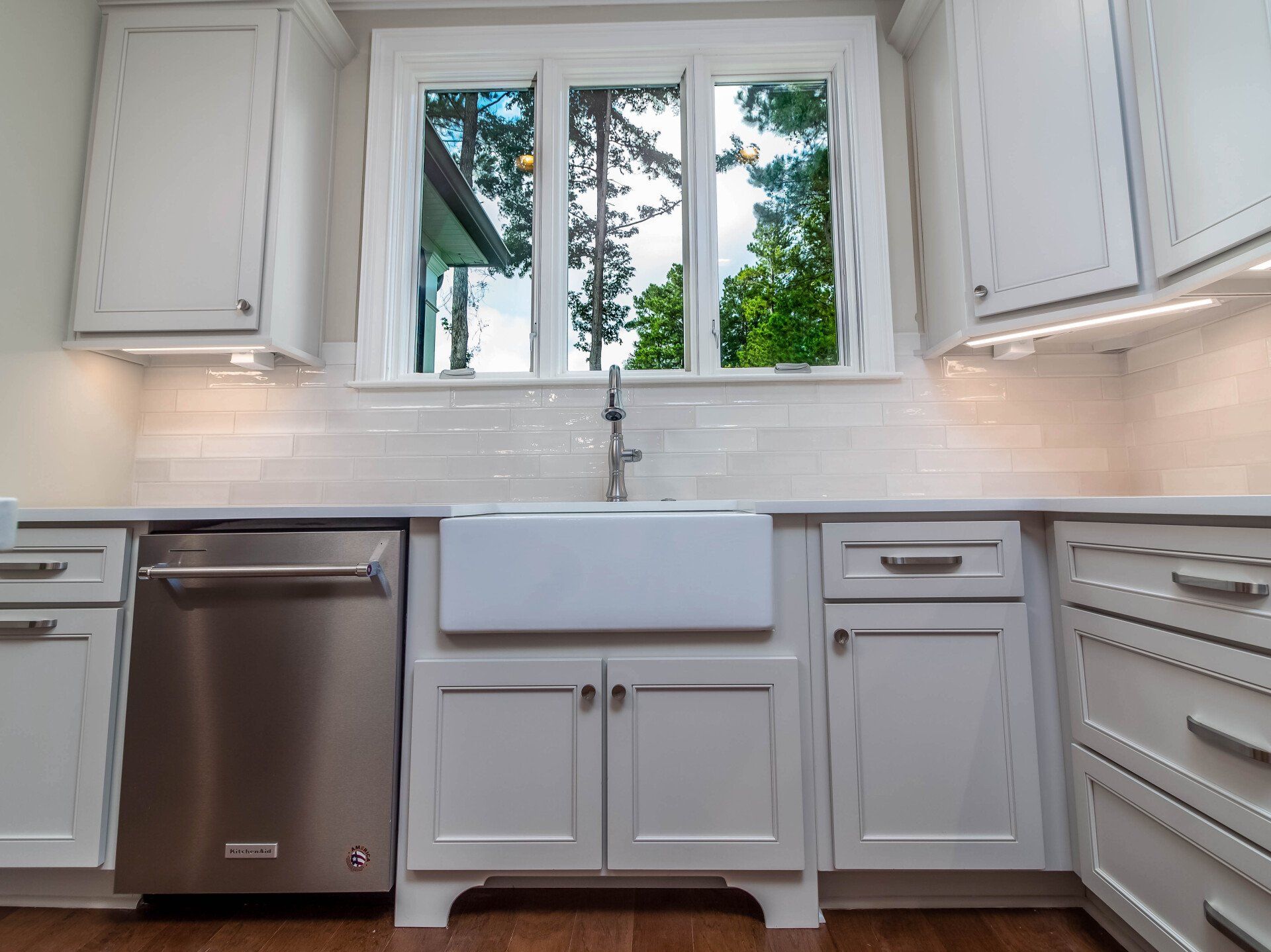 A kitchen with white cabinets and a stainless steel dishwasher