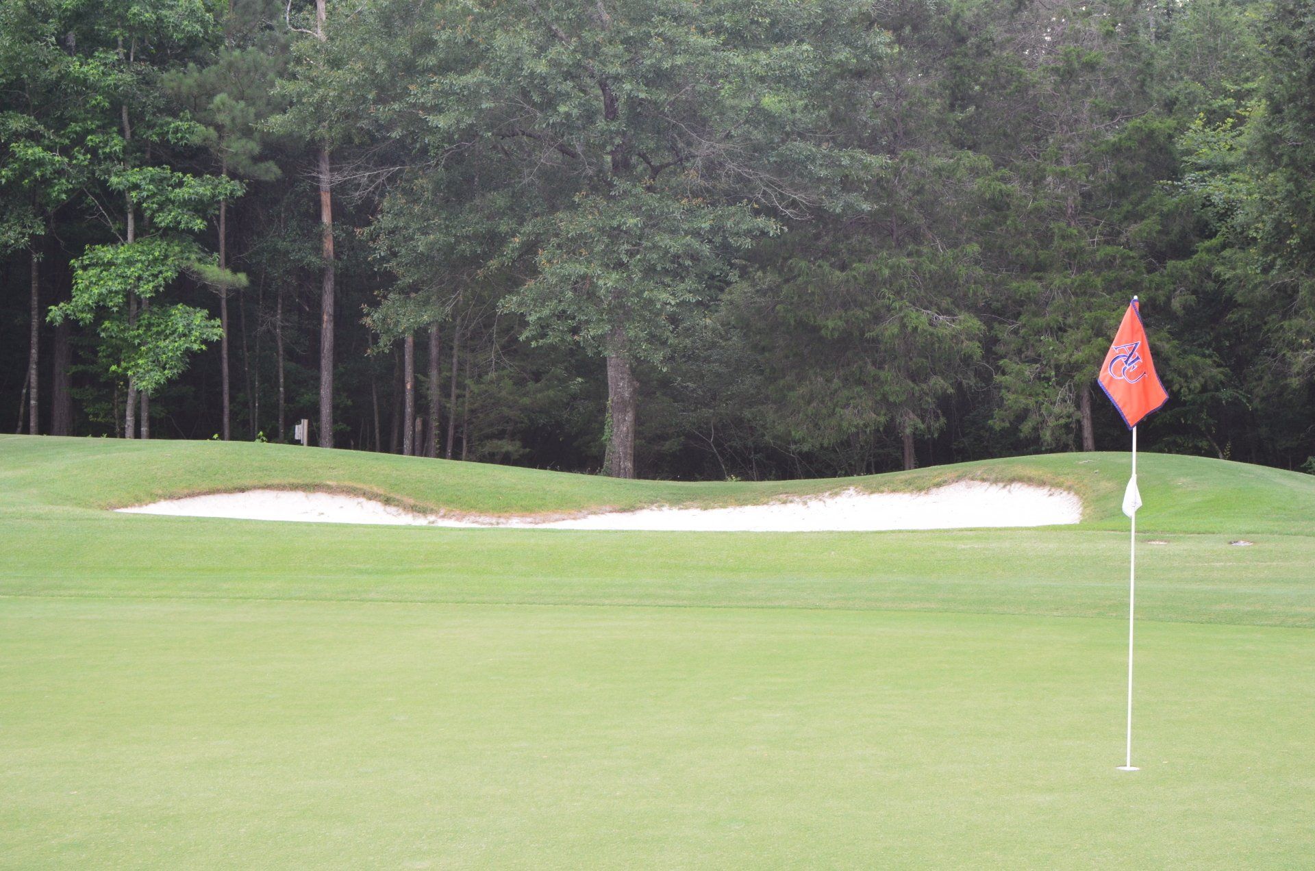 A golf course with a red flag on the green