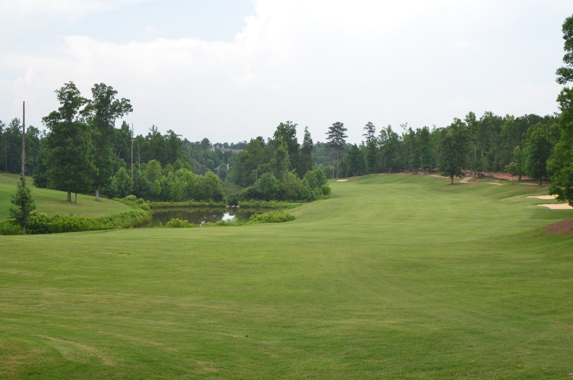A golf course with a pond in the middle of it