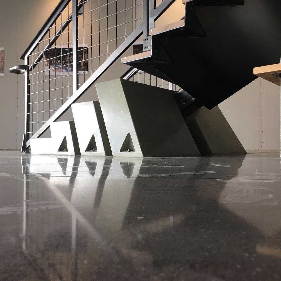 A staircase with a reflection of the stairs in the floor