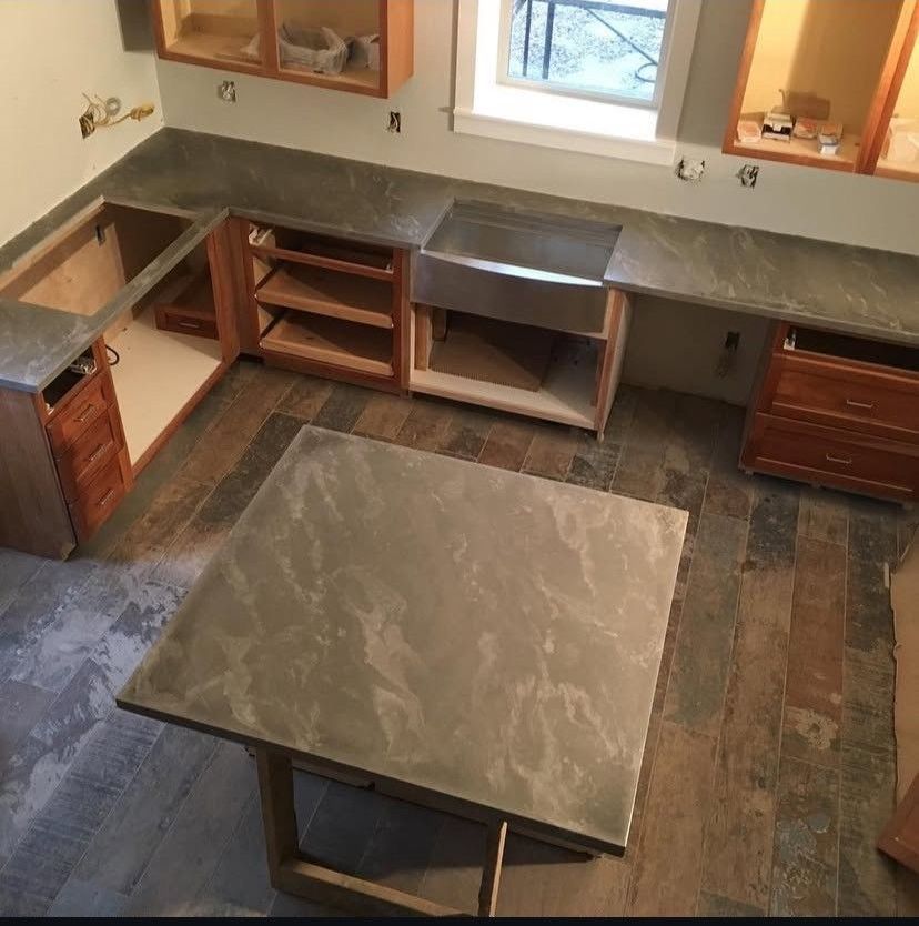 A kitchen with a counter and stools and a brick wall